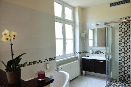 uma casa de banho com uma banheira e um lavatório e uma banheira em Corner Hotel & Kávéház em Dunaújváros