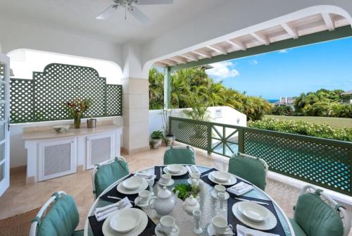 une salle à manger avec une table et des chaises sur un balcon dans l'établissement Sugar Hill - Frangipani by Blue Sky Luxury, à Saint James
