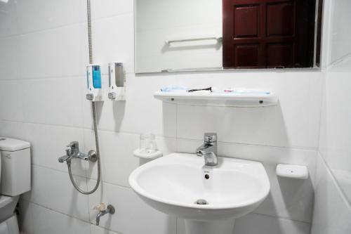 ein weißes Badezimmer mit einem Waschbecken und einem Spiegel in der Unterkunft SKY HOTEL - KHÁCH SẠN BẮC NINH in Bồ Sơn
