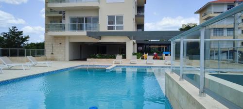 a swimming pool in front of a building at Moreno Paradise en Playa Juan Dolio in Los Corrales