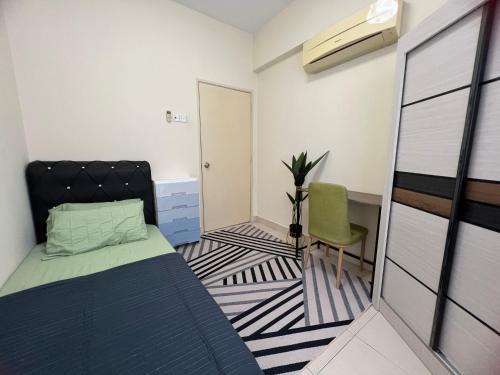 una piccola camera con letto e sedia di JR GUESTHOUSE ad Ampang