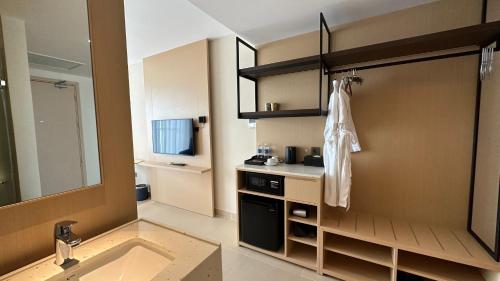 a bathroom with a sink and a mirror and a kitchen at The Aurora Home near International Airport in Miếu Ông