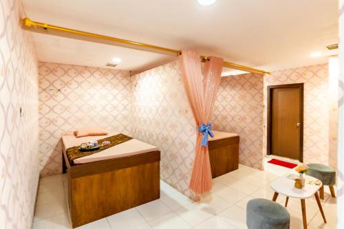 a small room with a bed and a table at Swiss-Belinn Malang in Malang