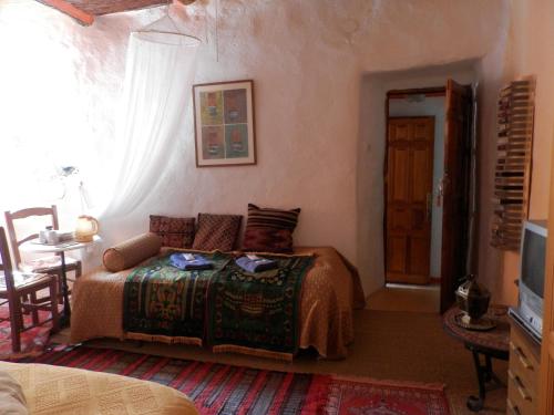 a bedroom with a bed and a table and a window at L'atelier B&B in Mecina Fondales