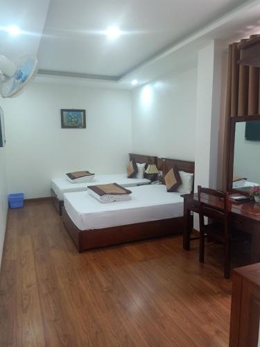 a bedroom with two beds and a table and a mirror at Khách Sạn Sông Hiến in Cao Bằng