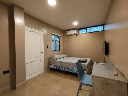 een slaapkamer met een bed, een bureau en een raam bij Hermosa suite acogedora y hermosa, Las Garzas 2 in Guayaquil