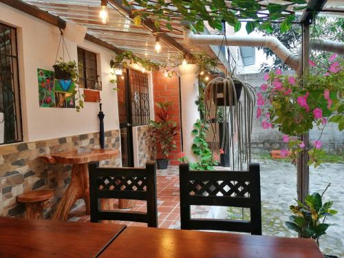 een patio met een tafel en stoelen en een gebouw bij Home Capybara Stay in Mindo