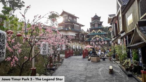 a street in an asian town with flowering trees and buildings at Swiss-Belinn Malang in Malang