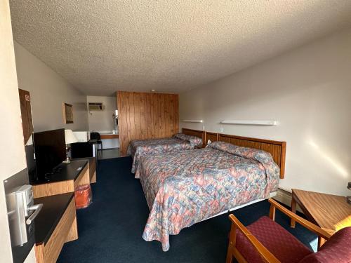 a hotel room with two beds and a flat screen tv at Howard Johnson by Wyndham Edson in Edson