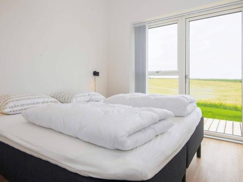 duże białe łóżko w pokoju z dużym oknem w obiekcie 12 person holiday home in Lemvig-By Traum w mieście Lemvig