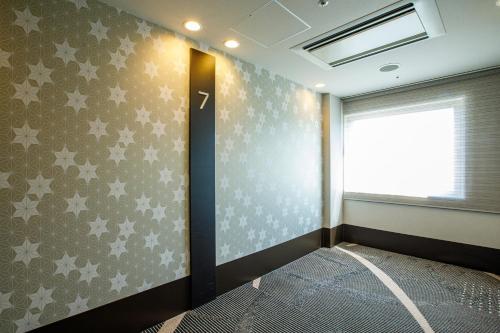 a room with a bed and a window with stars at Hotel Sunroute Fukuchiyama in Fukuchiyama