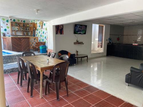 Zimmer mit einem Tisch und Stühlen sowie einem Wohnzimmer in der Unterkunft Hotel Manakin Tayrona in El Zaino