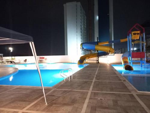 - une piscine avec toboggan la nuit dans l'établissement Hermoso apartamento con piscina ubicado cerca a los principales centros comerciales, à Ibagué