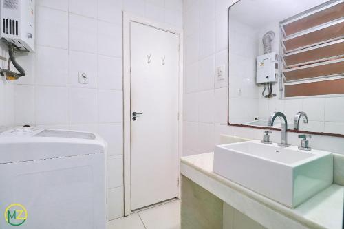 Baño blanco con lavabo y espejo en Studio com vista lateral para o mar em Copacabana en Río de Janeiro