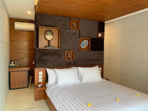 a bedroom with a bed and a clock on the wall at Bale Solah Lombok Holiday Resort in Senggigi 