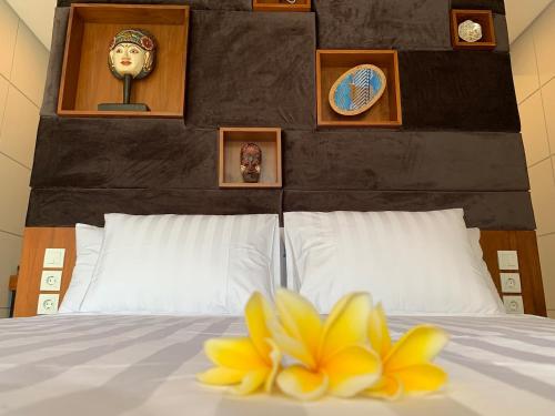 a bed with a yellow flower on top of it at Bale Solah Lombok Holiday Resort in Senggigi 
