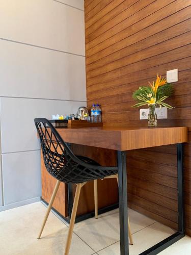 a wooden desk with a chair and a vase of flowers at Bale Solah Lombok Holiday Resort in Senggigi 