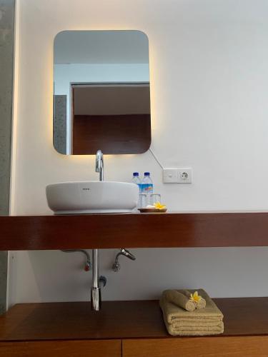 a bathroom with a sink and a mirror at Bale Solah Lombok Holiday Resort in Senggigi 