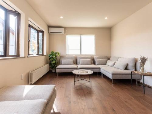 a living room with a couch and a table at Oguma House in Nozawa Onsen