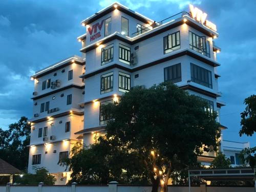 a white building with a tree in front of it at HOTEL VTV DỐC LẾT in Ninh Hòa