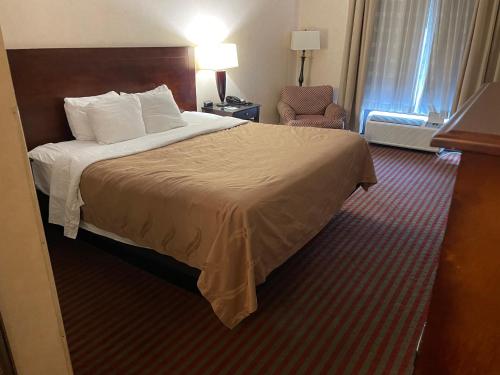 サマセットにあるQuality Inn & Suitesのベッドと椅子付きのホテルルーム