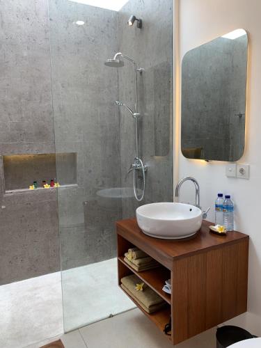 a bathroom with a shower with a sink and a mirror at Bale Solah Lombok Holiday Resort in Senggigi 