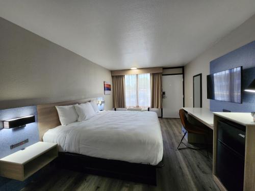 Habitación de hotel con cama y escritorio en Smart Stay Lafayette en Lafayette
