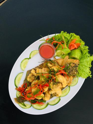 a plate of food with a salad on a table at Hotel Nature Bromo and Resort in Pasuruan