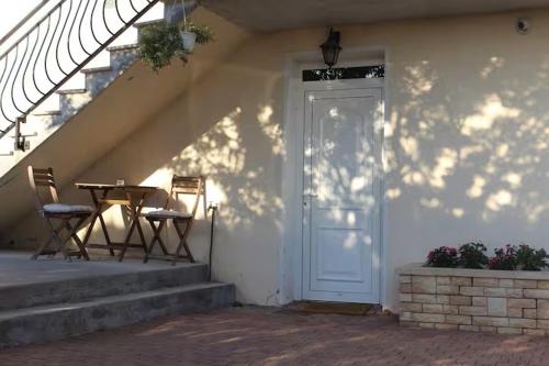 eine weiße Tür zu einem Haus mit einem Tisch und Stühlen in der Unterkunft chambre avec entrée indépendante in Saint-Priest