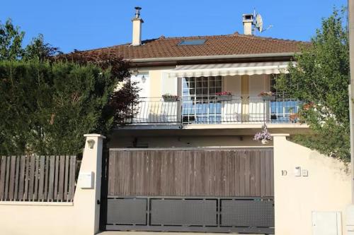 une maison blanche avec un portail et une clôture dans l'établissement chambre avec entrée indépendante, à Saint-Priest