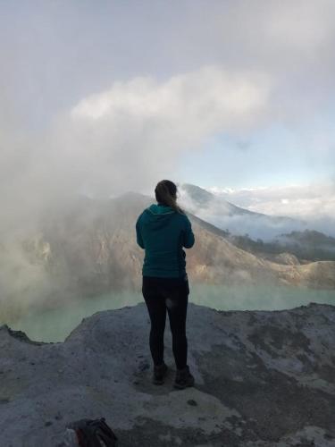 a woman standing on top of a mountain flying a kite at Ijen Transito 2 HOMESTAY in Ketapang