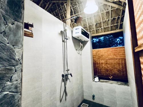 a shower in a bathroom with a camera on the wall at Thavill Retreat HaGiang in Ha Giang