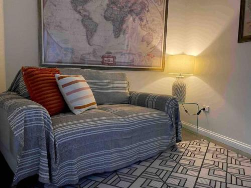 a couch in a living room with a map on the wall at Sunbird Studio Apartment: private apartment walking distance from the beach in Trinity Beach