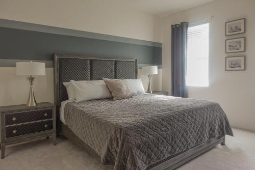 a bedroom with a bed and two lamps and a window at Waterfront Brand New Modern Luxury 8 BR pool house! Sleeps 16 in Kissimmee