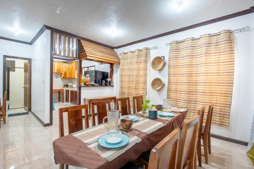 a dining room with a table and wooden chairs at Siesta Siargao in General Luna