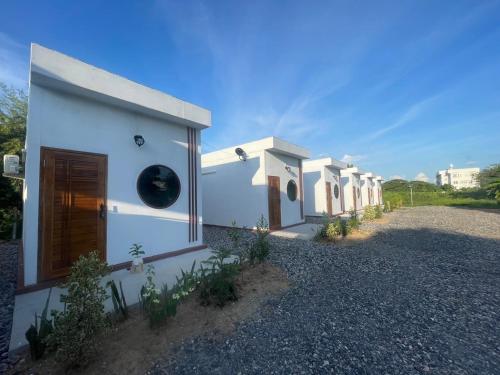 a row of white houses on a gravel road at Muji House Resort in Non Sang