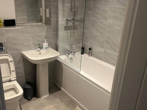 a bathroom with a shower and a sink and a toilet at Luxe City Centre in Birmingham