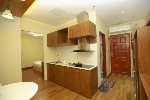 uma cozinha com armários de madeira e um lavatório num quarto em HOTEL KEIO YANGON em Rangoon Ahlone