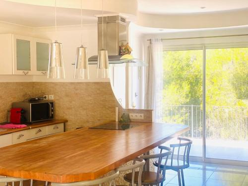 una cucina con un tavolo di legno e alcune sedie di Villa Nimes a Nîmes