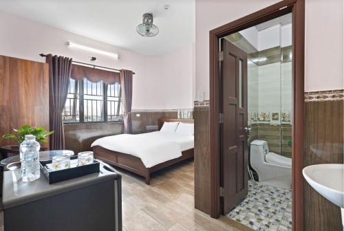 a bedroom with a bed and a bathroom with a sink at Mộc Nhiên Hotel Da Nang in Da Nang