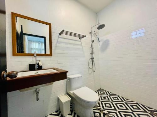 La salle de bains est pourvue de toilettes, d'un lavabo et d'un miroir. dans l'établissement home near MRT Tha Phra Villa sookkasem, à Bangkok Yai