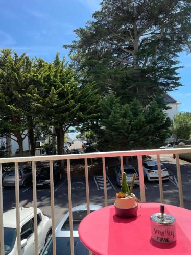 a pink table with a plant on top of a balcony at Appartement La Baule - Plage Benoît in La Baule
