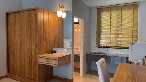eine Küche mit einem Holzschrank und einem Waschbecken in der Unterkunft Look at Home Lamphun in Lamphun