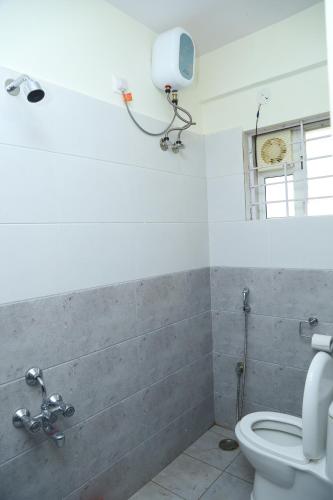 La salle de bains est pourvue de toilettes et d'une caméra murale. dans l'établissement Hotel Bangalore Airport inn, Airport Pickup & Drop Available 24X7, à Yelahanka
