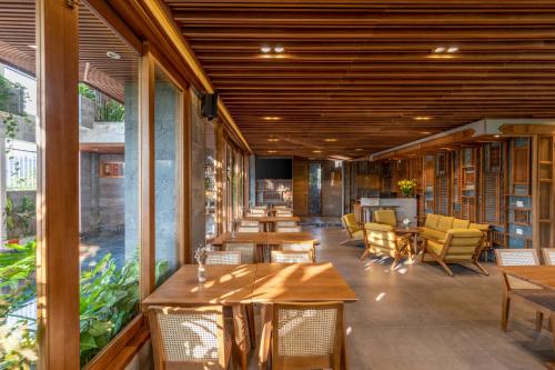 a restaurant with wooden ceilings and tables and chairs at Bonny Boutique Hotel Da Nang in Da Nang