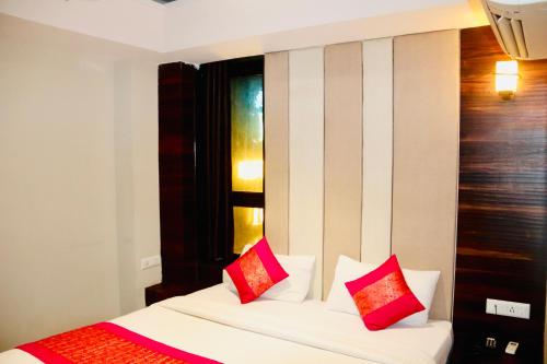 1 dormitorio con 1 cama con almohadas rojas y blancas en Hotel Magic Tree Karol Bagh Metro Station New Delhi, en Nueva Delhi