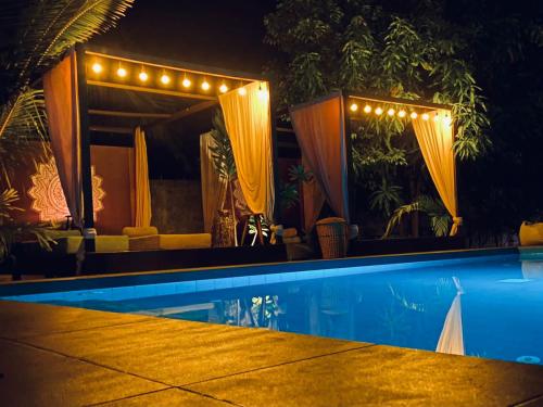 a house with a swimming pool at night at Richards Cabanas in Tissamaharama