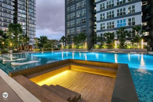 a swimming pool in the middle of two tall buildings at Selesa Homestay Canopy Hills Kajang in Hulu Langat