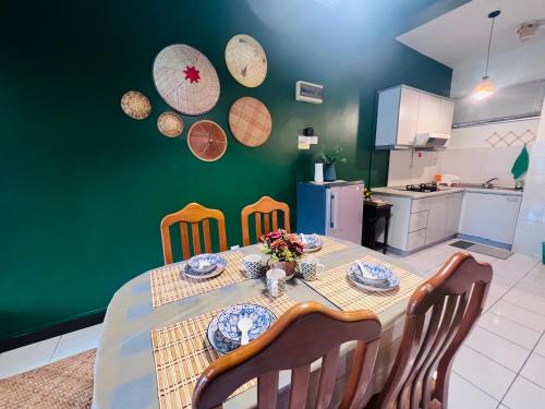 ein Esstisch mit Stühlen und einer grünen Wand in der Unterkunft The Heritage@Selesa Hillhomes Bukit Tinggi Berjaya Hills Bentong in Bentong