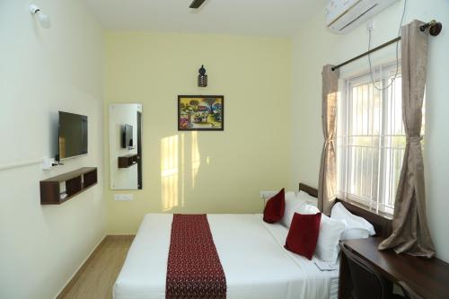 a bedroom with a white bed and a window at Hotel Bangalore Airport inn, Airport Pickup & Drop Available 24X7 in Yelahanka